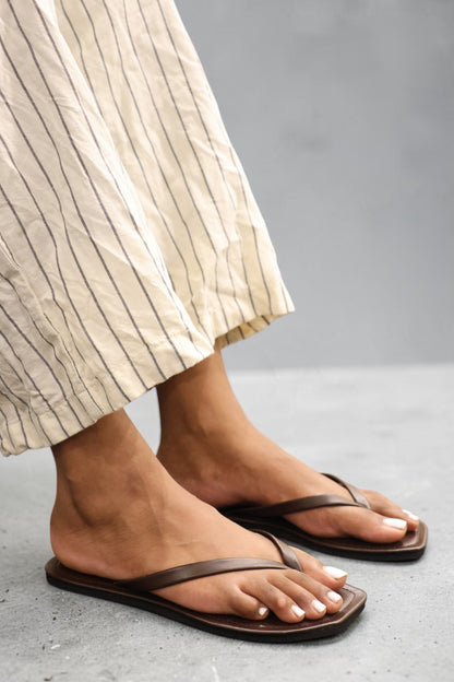 LEWIJE Mirissa flip flops in espresso brown, worn with striped linen trousers